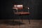 industrial chair with a leather or faux-leather seat, metal legs and wooden armrests