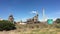 Industrial chimney with smoke against a clear blue sky