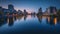 Industrial Cityscape with Towering Structures, Glowing City Lights, and Reflections on a Calm River