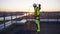 Industrial climber on rooftop hangs safety rope on shoulders