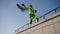 Industrial climber throws rope down from roof of building