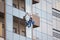 Industrial climber wash the windows of modern skyscraper