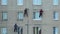 Industrial climbers work at height. Workers cover up the seams on the wall of a prefabricated house with putty.