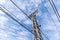 Industrial composition with power lines and vintage metal tower, blue sky with light clouds