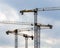 Industrial construction crane silhouettes isolated on blue cloud