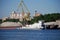 Industrial crane for loading barges stands on the background of huge piles of sand and gravel on the banks of the Khimki reservoir