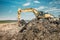 industrial details with excavator using heavy duty scoop at garbage dumpsite