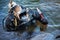 Industrial diver with scuba gear and hammer working in the water at the shore reinforcement, copy space