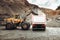 Industrial dumper trucks and wheel loader bulldozer working on highway construction site, loading and unloading gravel and earth m