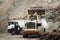 Industrial dumper trucks and wheel loader working on construction site, loading and unloading gravel and earth. heavy duty machine