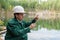 Industrial ecologist takes a sample of water from lake at the site of a flooded mining pit