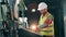 Industrial employee in a hardhat is operating a console