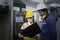 Industrial engineer worker woman and man wearing helmet  holding and looking at black file folder of document  discussing and