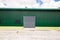 Industrial facade, metal door of warehouse.  Grey door with green wall