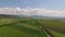 Industrial fields surrounded by mountains shooting from a bird`s-eye view.