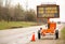 An industrial flashing warning sign informing motorists about COVID-19.