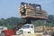 An industrial forklift loading a large bundle of l