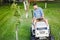 Industrial gardener driving a riding lawn mower in a garden