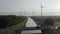 Industrial Harmony: Aerial Over Bridge, River, and Wind Turbines