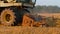 Industrial harvester harvesting autumn crop on autumn field in countryside