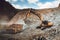 Industrial heavy duty excavator moving gravel on highway construction site