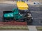 Industrial heavy road paver multifunctional modern, repair of road pavement in an urban environment, noisy work