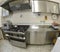 industrial kitchen with large stainless steel gas stoves and the