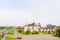 Industrial landscape with chemical plants, pipes and columns. Below is an orange tractor. Smoke comes from the reactor.