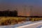 Industrial landscape - illuminated railway station by winter night with snowfall