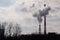 Industrial Landscape, Krakow, Poland: White-red high pipes of the plant with smoke or steam coming out on background of gray-white