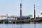 Industrial landscape, pulp and paper mill with stacks of logs on the river bank