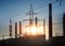 Industrial landscape. Sunset over the power line and pipes of combined heat and power plant