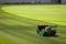 Industrial lawn mower machine on a soccer stadium with freshly installed and trimmed new turf
