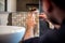 Industrial man worker applying mosaic tiles in bathroom walls