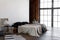 Industrial open space loft interior of a bedroom with big windows with daylight