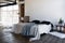 Industrial open space loft interior of a bedroom with big windows filled with daylight