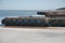 Industrial pier with blue tires and white pipes next to icy water