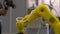 Industrial robot manipulator yellow color performs movements that are programmed in the control unit