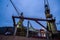 Industrial shipyard at night, floating dock with a ship under repair, lit cranes on duty, marine engineering scene. Ship