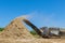 Industrial shredder for wood chips from roots in a work conveyor under a stationary shredding machine