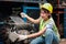 Industrial smiling woman worker wearing helmet repairing with machinery at manufacturing plant factory industry, Asian beautiful