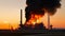 Industrial smoke from the chimney of an oil refinery at sunset