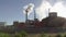 Industrial smokestack with smoke on blue sky background