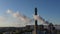 Industrial smokestack with smoke on blue sky background, aerial