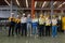 Industrial teamwork. Professionals donning safety hard hats standing together in a bustling factory