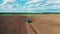 Industrial tractor plows soil on a big farmland.