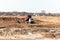 An industrial truck is working on a construction site. Clearing land for the construction of new houses and a new microdistrict