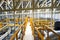 Industrial walk way with yellow handrail and steel structure roof inside factory