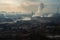 industrial wasteland, with smoke and haze from smokestacks covering the landscape