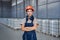 industrial woman engineer in hardhat standing in factory with arms folded